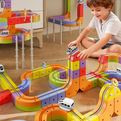 Enfant qui construit un grand circuit de train flexible au sol
